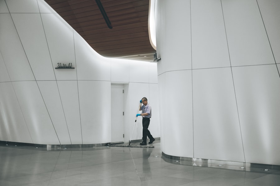 Hall blanco de un edificio con una persona al fondo, empresa de aseo en Chile